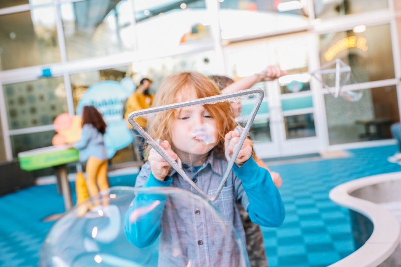 Child blowing large bubbles.
