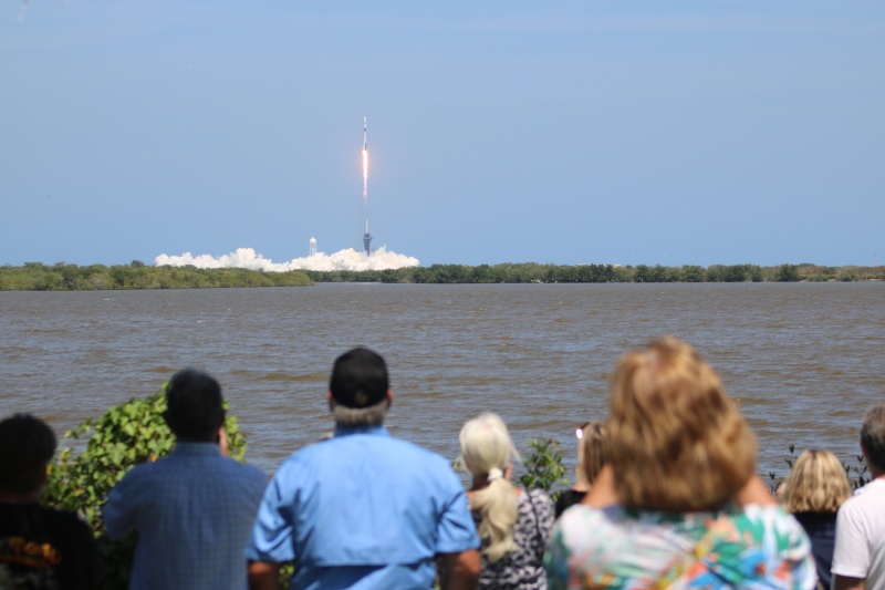 People watching a rocket launch from a distance.